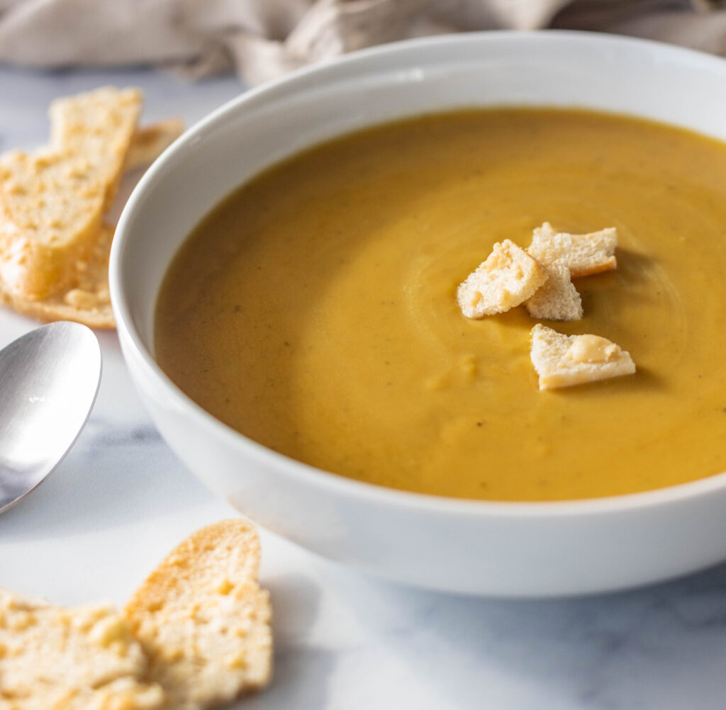 Bowl of hot butternut soup with croutons